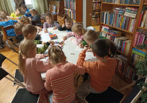 Przedszkolaki kolorują zimowe i świąteczne obrazki.