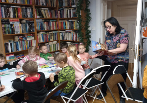 Dzieci słuchają treści książki „Gwiazdka! Nie przeszkadzać!”.