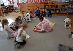 Pani Paulina rozdaje przedszkolakom materiały do samodzielnej pracy.