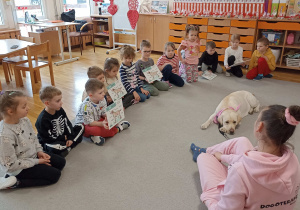 Dzieci pokazują wykonane zadanie na planszach edukacyjnych.