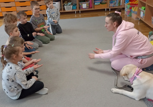 Pani instruktorka tłumaczy, w jaki sposób karmić psa.