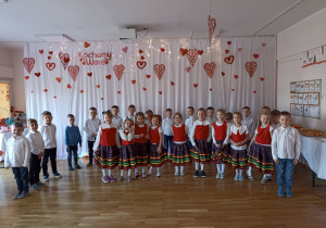 Zdjęcie grupowe na tle okolicznościowej dekoracji.