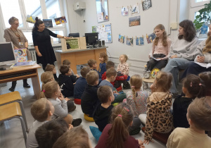 Panie tłumaczą dzieciom, co będą robiły podczas wizyty w bibliotece.