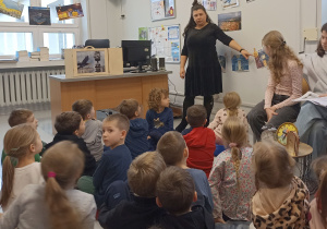 Pani Kasia pokazuje zegary na ilustracjach.