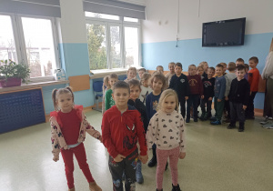 Grupa pomarańczowa na szkolnym korytarzu.