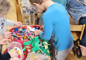 Dzieci wybierają materiały do wykonania masek karnawałowych.