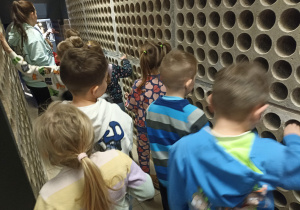 Grupa pomarańczowa zwiedza wnętrza budynku.